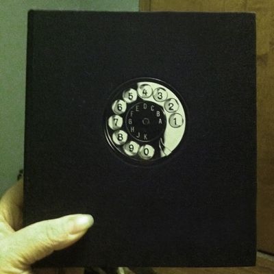 picture of my address book, a small square book with the image of a rotary phone dial on its front
