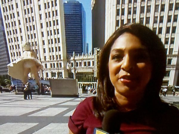 screen cap of NBC5 reporter Alicia Roman standing in front of Chicago's Marilyn Monroe sculpture, seen from behind, her sculpted underpants in full view