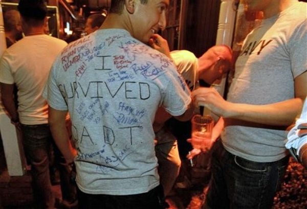 image of a man in a t-shirt reading 'I Survived DADT' with signatures all over it
