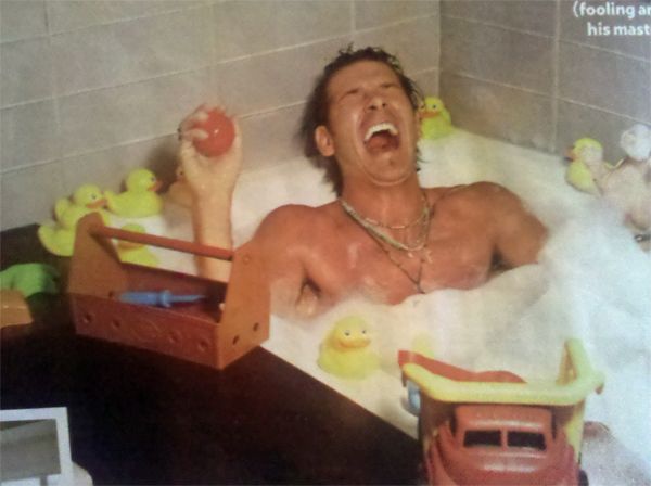 a People magazine photograph of TV host Ty Pennington in a bubble bath in his apartment, playing with rubber ducks and a toy truck and laughing with his mouth wide open