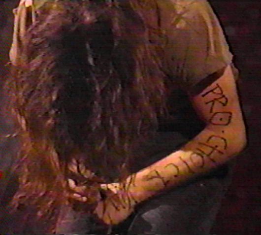 image of Eddie Vedder leaning forward, his long hair cascading around him, with PRO-CHOICE scrawled on his arm in black marker