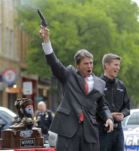 photo of Rick Perry hollerin' while pointing a gun in the air at a public event