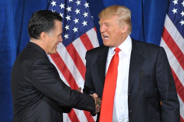 image of Mitt Romney and Donald Trump shaking hands in front of a bunch of US flags, and Trump's making some weird-ass face