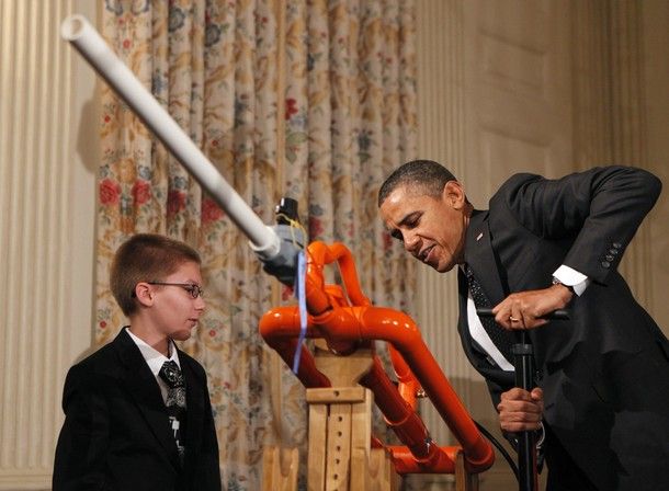President Obama with a young white boy and a big orange contraption which is apparently an Extreme Marshmallow Cannon