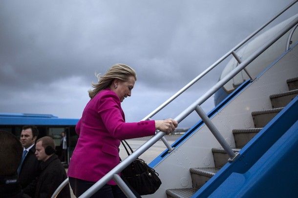 image of Secretary of State Hillary Clinton walking up the steps of an airplane