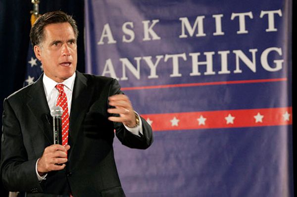 image of Mitt Romney with a microphone standing in front of a giant sign reading 'Ask Mitt Anything'