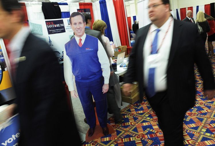 image of people walking past a cardboard cut-out of Rick Santorum at CPAC