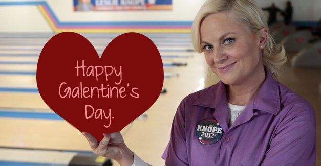 an image of Amy Poehler as Leslie Knope from Parks and Recreation, at a bowling alley; her bowling ball has been replaced with a giant red heart reading in pink lettering, 'Happy Galentine's Day.'