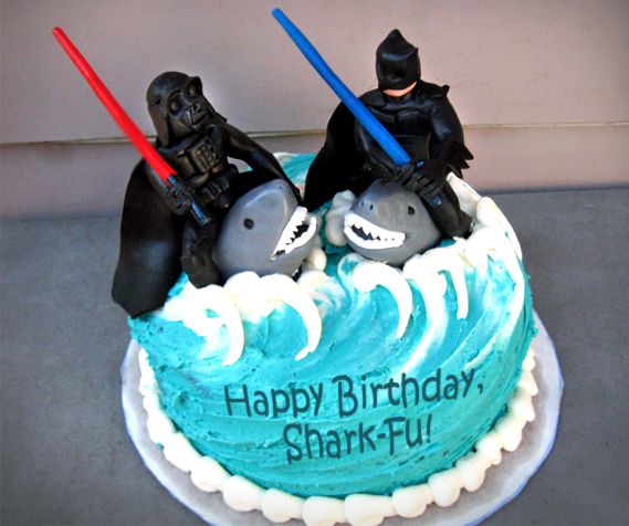 image of a birthday cake reading 'Happy Birthday, Shark-Fu!' and featuring Darth Vader and Batman fighting each other with lightsabers while riding on sharks' backs