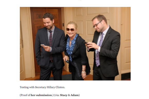 image of Clinton posing with the two men, who are pretending to text her