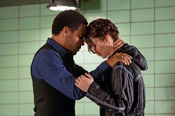 image of Lenny Kravitz as Cinna and Jennifer Lawrence as Katniss leaning their heads together in a supportive gesture, just before she is to be launched into The Hunger Games to fight for her life