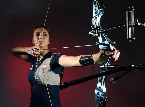 image of a white woman posing with a bow and arrow
