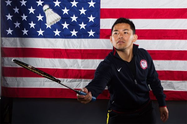 image of a Vietnamese-American man playing badminton in front of a US flag