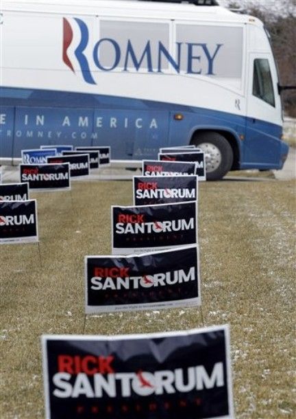 image of Romney campaign bus pulling up next to a field of Rick Santorum signs
