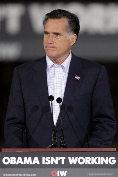 image of Mitt Romney speaking in an empty factory behind a banner reading 'Obama Isn't Working'