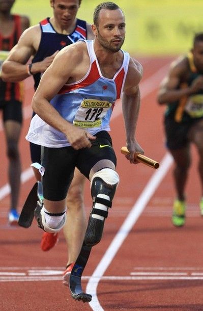 image of male runner Oscar Pistorius, who has two prosthetic legs, running a relay, carrying a baton