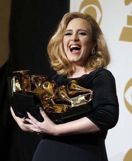 image of Adele backstage at the Grammys holding her six awards