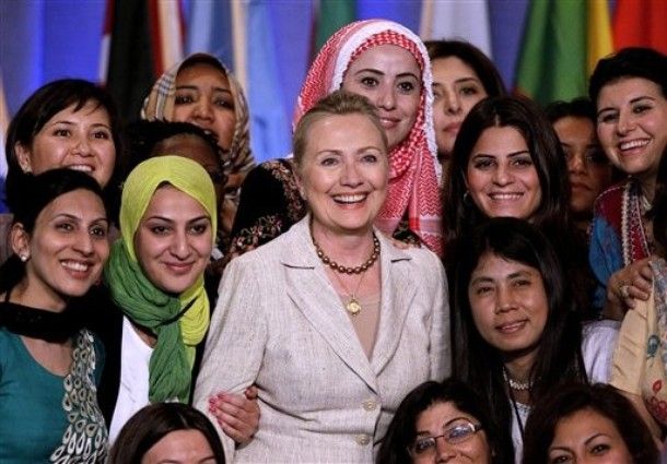 image of Hillary Clinton smiling, surrounded by lots of young women of many ethnicities