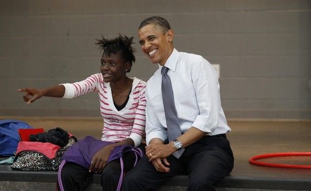 image of President Obama sitting next to an African-American young woman; she is pointing at something and he is grinning broadly