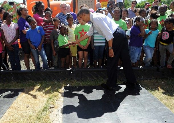 President Obama greets a crowd of children outside the Boys and Girls Club, and shakes the hand of a young African-American girl