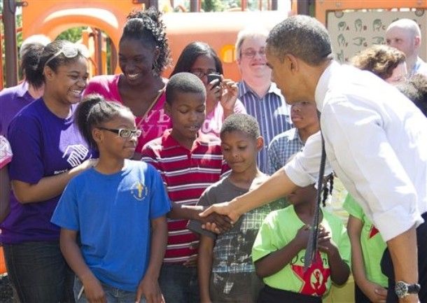 President Obama shakes a young African-American boy's hand outside the Boys and Girls Club