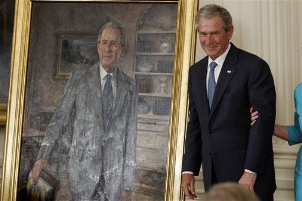 image of George W. Bush making one of his classic Bush-faces while standing next to his official presidential portrait