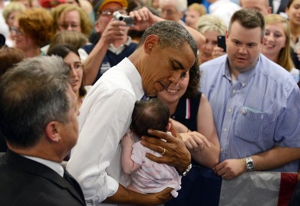 image of President Barack Obama cradling a baby, so gently and lovingly
