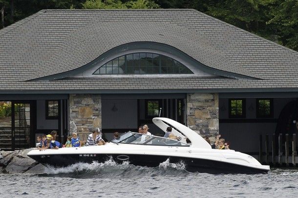 image of a boat in the water in front of a beautiful and lavish brick building