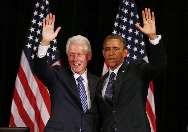 image of Bill Clinton and Barack Obama standing together in front of a flag and waving