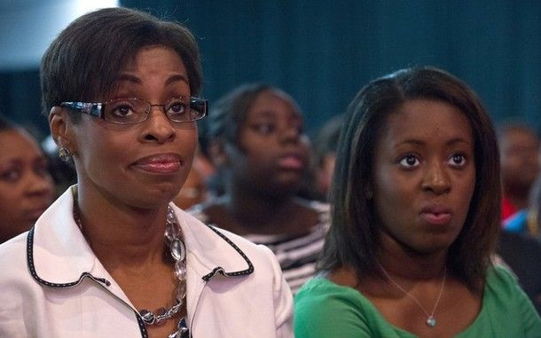 Two women sit in the audience of Romney's NAACP address, looking dubious