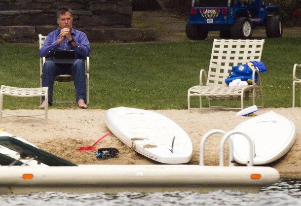 Mitt Romney sits in a lawn chair on the shore alone at his vacation home in New Hampshire