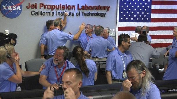 In this photo released by NASA/JPL-Caltech, Mars Science Laboratory (MSL) team members react after the Curiosity rover successfully landed on Mars and as first images start coming in to the Jet Propulsion Laboratory, Sunday, Aug. 5, 2012 in Pasadena, Calif.