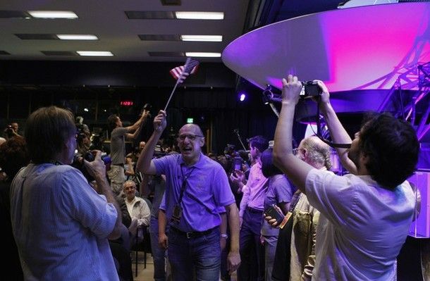Mars Science Laboratory Curiosity rover team member Miguel San Martin (center) waves an American flag after a successful rover landing, as he arrives for a news conference at NASA's Jet Propulsion Lab in Pasadena, California August 5, 2012.