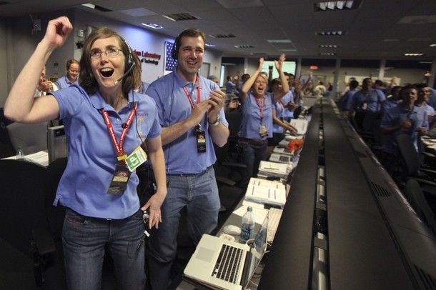 Kelley Clarke, left, celebrates as the first pictures appear on screen after a successful landing inside the Spaceflight Operations Facility for NASA's Mars Science Laboratory Curiosity rover at Jet Propulsion Laboratory in Pasadena, Calif. , Sunday Aug. 5, 2012.
