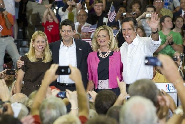 The Romneys and the Ryans waving in the middle of a crowd at a campaign event
