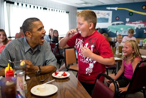 image of President Barack Obama makes an open-mouth face as a little white boy eats ice cream beside him