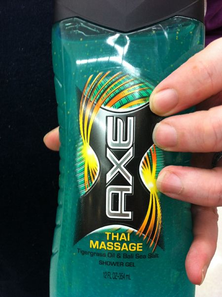 image of Iain's hand holding a bottle of Axe shower gel called 'Thai Massage'