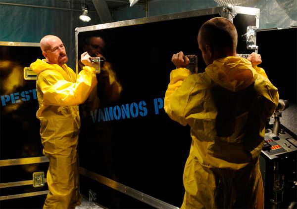 image of Jesse (Aaron Paul) and Walt (Bryan Cranston) in hazmat suits moving giant black cases labeled 'Vamonos Pest'