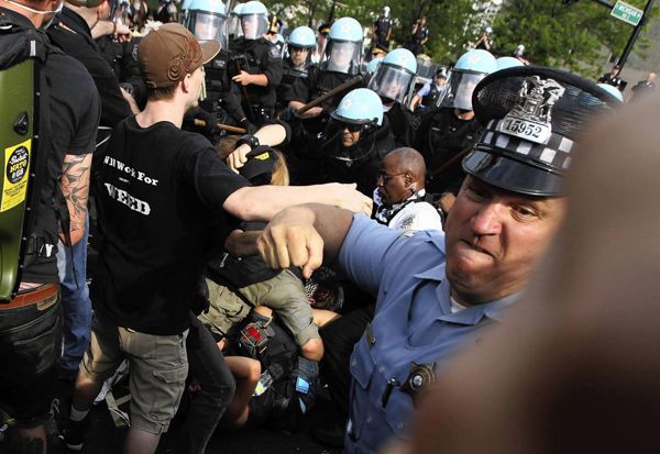 a protestor's view in the midst of a melee, of a uniformed officer about to throw a punch