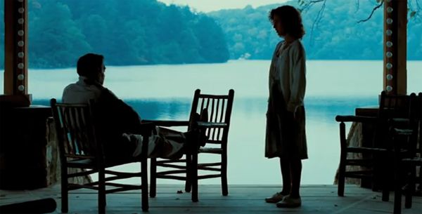 image of Jerry Orbach and Jennifer Grey from Dirty Dancing, in which Orbach is sitting on a deck chair overlooking a lake and Grey is standing and talking to him.