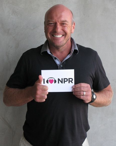 image of actor Dean Norris holding up a sign reading I Heart NPR