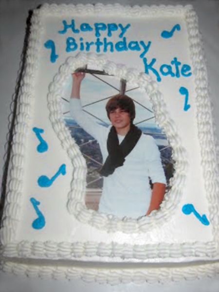 image of a white Justin Bieber cake that has Happy Birthday, Kate written on it in blue icing