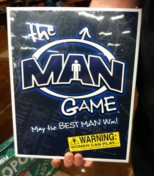 image of Iain's hand holding a board game called 'The Man Game.'