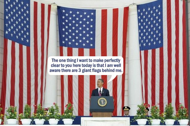 image of President Obama standing at a podium in front of three flags, to which I have added a dialogue bubble reading: 'The one thing I want to make perfectly clear to you here today is that I am well aware there are 3 giant flags behind me.'