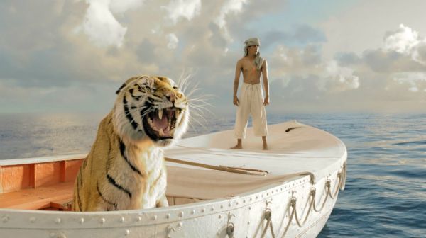 promotional image for 'Life of Pi' film, featuring an Indian boy and a tiger on a small boat at sea