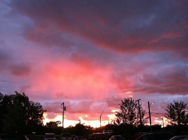 image of the setting sun from the restaurant parking lot; the sky is just afire with bright pink light