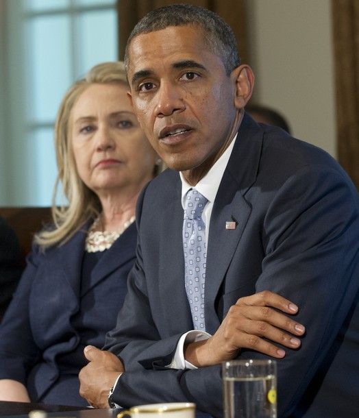 image of Secretary of State Hillary Clinton sitting next to President Barack Obama during a cabinet meeting