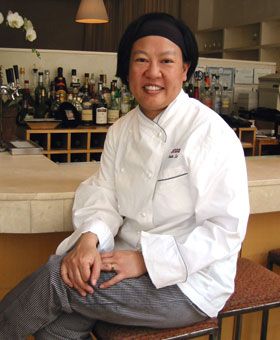 image of Chef Anita Lo, a middle-aged Asian American woman, sitting on a stool