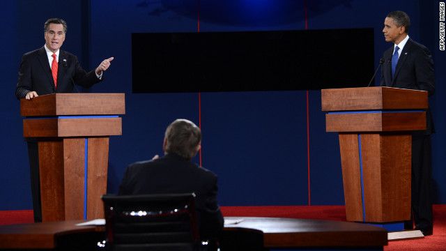 scene from the debate; Mitt Romney is gesturing aggressively at the President, who looks back at him stoically, while Jim Lehrer sits idly by