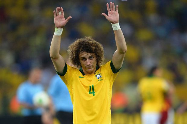image of Brazil player David Luiz, on the pitch, wearing his Brazil jersey, his arms in the air